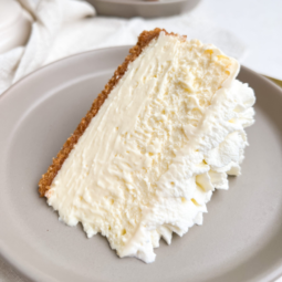 a slice of cheesecake on a small plate, showcasing a thin crust, a smooth and creamy texture