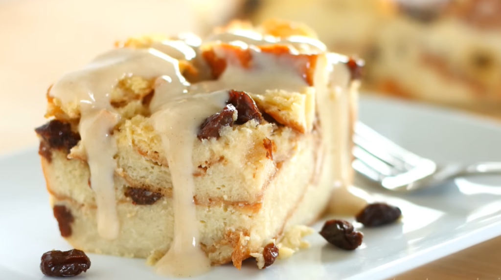 a close up of a piece of bread pudding with raisins and a fork