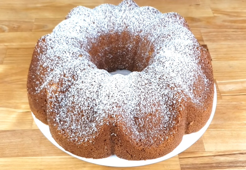 A timeless vanilla Bundt cake displayed on a table, lightly dusted with powdered sugar.