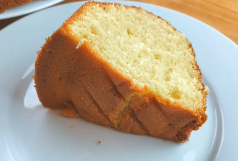 A slices of vanilla Bundt cake on a small plate, featuring a soft texture and a beautifully golden crust.