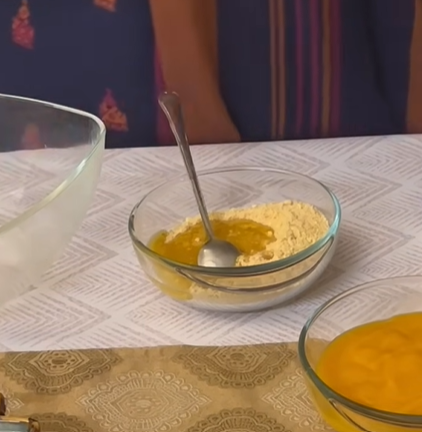 Butter being poured over crushed Nilla wafers in a glass bowl.