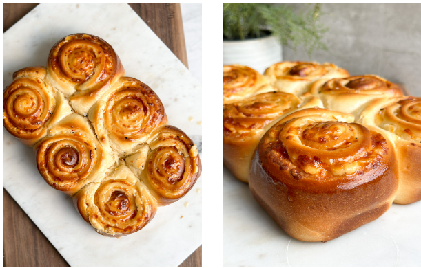 Six golden-brown cheesy bread rolls arranged on a rustic serving board, topped with a glossy honey butter glaze for added richness.